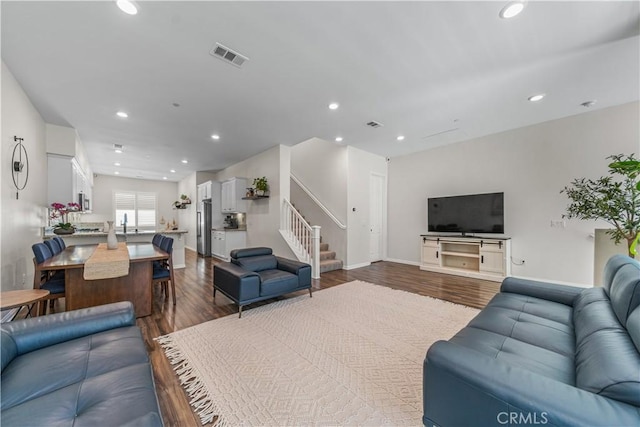 living area featuring wood finished floors, stairway, recessed lighting, and baseboards