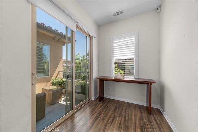 doorway featuring wood finished floors and baseboards