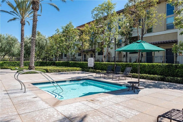 view of swimming pool featuring a patio area and fence