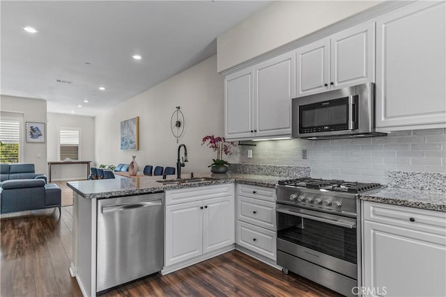 135 Neptune, Irvine, CA 92618 - kitchen with stainless steel appliances, a sink, a peninsula, open floor plan, and dark wood-style flooring