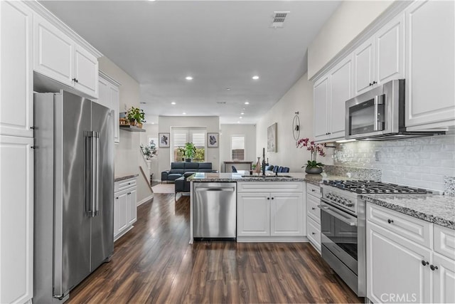 135 Neptune, Irvine, CA 92618 - kitchen with premium appliances, a sink, open floor plan, white cabinetry, and recessed lighting