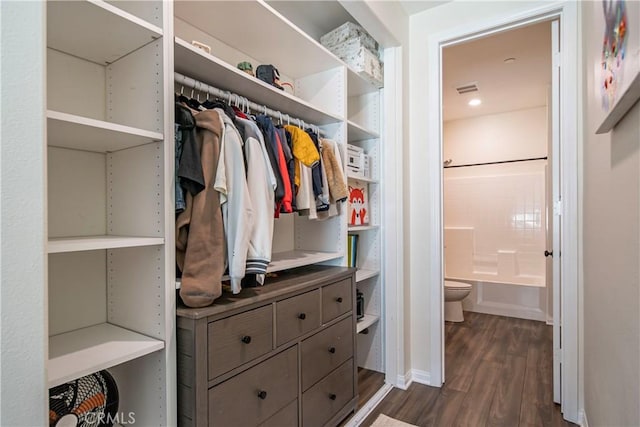 walk in closet featuring dark wood-style flooring