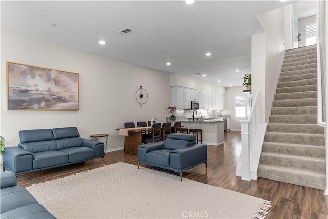 living area with stairs, dark wood-style flooring, recessed lighting, and baseboards