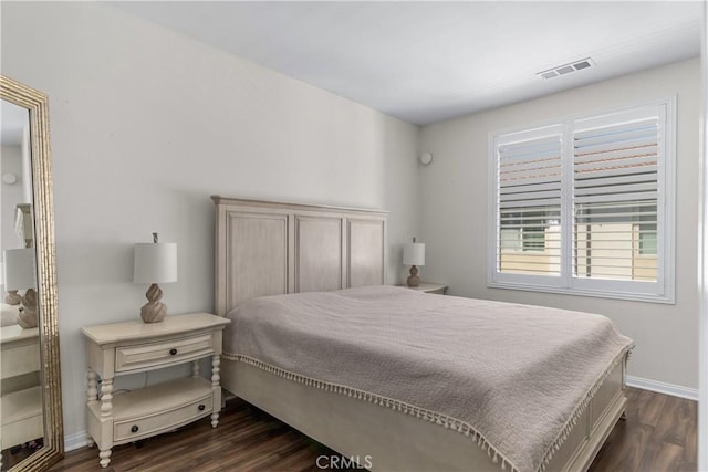 bedroom with dark wood finished floors and baseboards