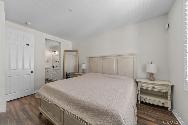 bedroom featuring dark wood-style floors, baseboards, and ensuite bath