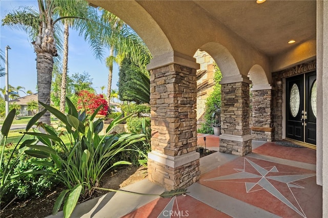 property entrance featuring stone siding and stucco siding