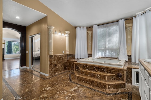 bathroom featuring inlaid floor details, vanity, marble tiled flooring, a bath, and baseboards