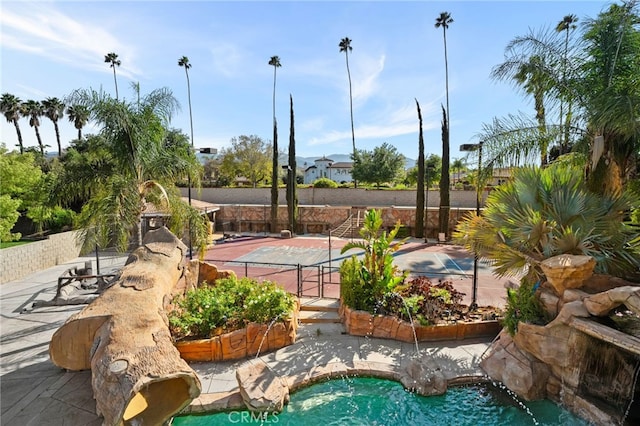 view of property's community featuring fence and a swimming pool