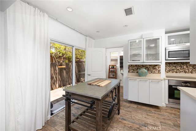 810 W Rte 66, Glendora, CA 91740 - kitchen featuring appliances with stainless steel finishes, light countertops, backsplash, wood finished floors, and white cabinetry