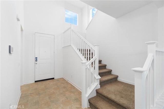 36936 Buccella Ln, Beaumont, CA 92223 - stairway featuring baseboards, stone finish flooring, and a towering ceiling