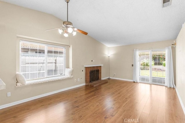 1866 Overland St, Colton, CA 92324 - unfurnished living room with lofted ceiling, a ceiling fan, wood finished floors, a textured ceiling, and a brick fireplace