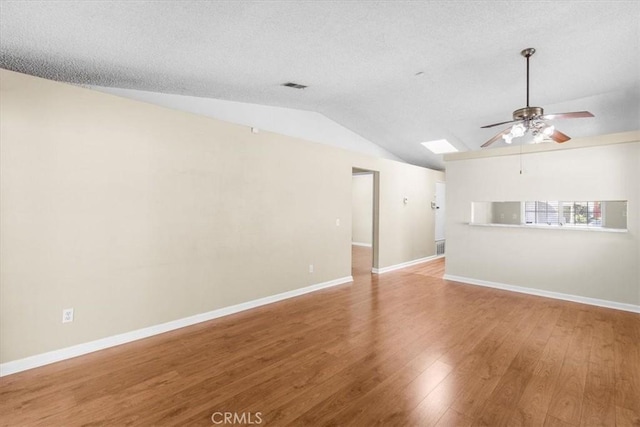 1866 Overland St, Colton, CA 92324 - unfurnished living room featuring ceiling fan, vaulted ceiling, wood finished floors, a skylight, and a textured ceiling