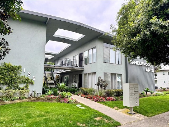 136 W Union Ave, Fullerton, CA 92832 - view of property exterior with mail area, stairway, a lawn, and stucco siding