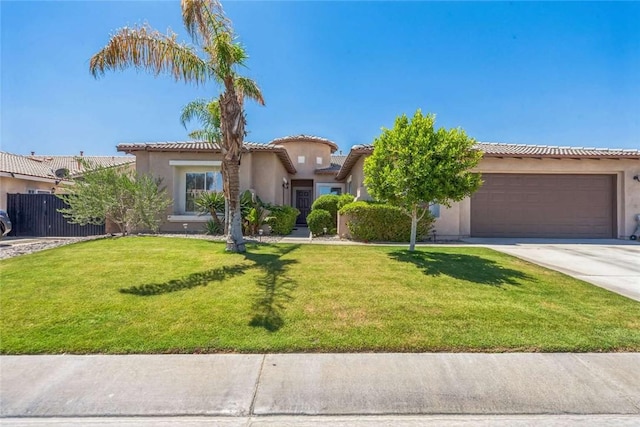 mediterranean / spanish-style home featuring concrete driveway, an attached garage, stucco siding, a tile roof, and a front yard