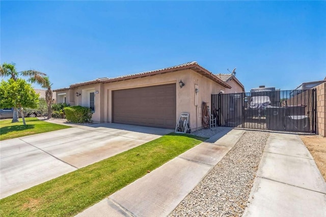 view of front of home featuring stucco siding, a tile roof, a garage, and driveway