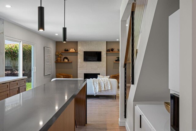 4687 Murat Ct, San Diego, CA 92117 - kitchen with light wood-style flooring, a fireplace, recessed lighting, and pendant lighting