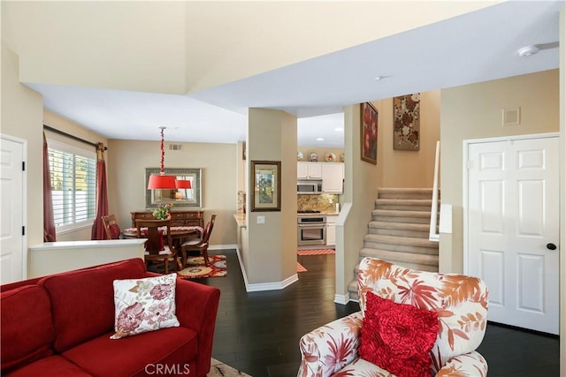 5126 E Paddington Ct Unit F, Orange, CA 92867 - living area featuring dark wood-style floors, stairway, and baseboards
