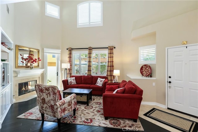 5126 E Paddington Ct Unit F, Orange, CA 92867 - living room with a towering ceiling, plenty of natural light, a fireplace, and wood finished floors
