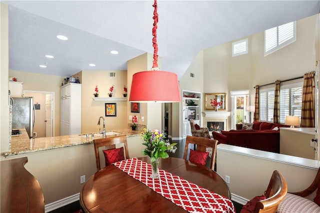 5126 E Paddington Ct Unit F, Orange, CA 92867 - dining space with a warm lit fireplace, recessed lighting, and a towering ceiling