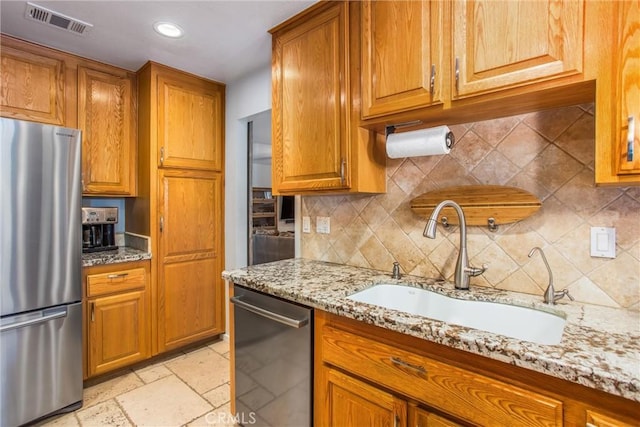 9914 Albany Ave, Rancho Cucamonga, CA 91701 - kitchen featuring stainless steel appliances, a sink, brown cabinetry, light stone countertops, and recessed lighting