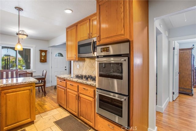 9914 Albany Ave, Rancho Cucamonga, CA 91701 - kitchen featuring stainless steel appliances, backsplash, light stone counters, brown cabinets, and recessed lighting