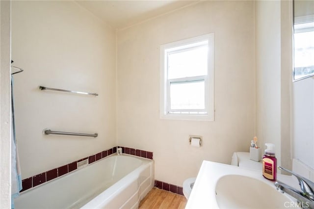 bathroom featuring a sink, plenty of natural light, toilet, and a garden tub