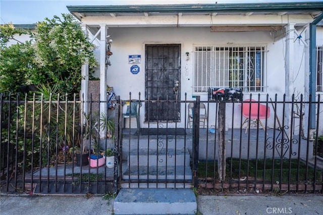 property entrance featuring fence, a gate, and a porch