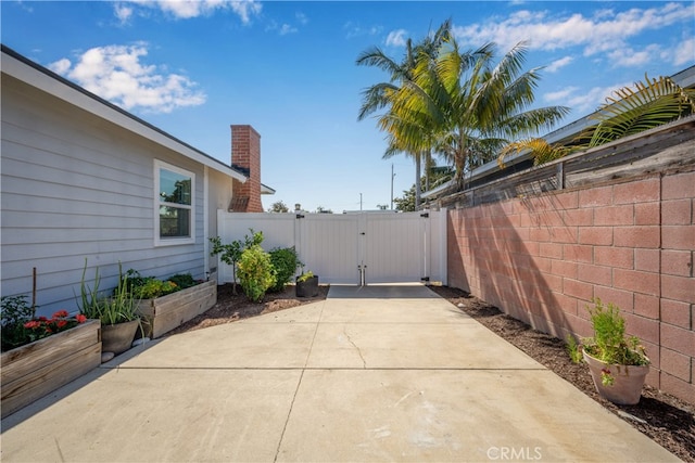 2731 N Rutgers Ave, Long Beach, CA 90815 - view of property exterior featuring a gate, a patio, fence, and a chimney