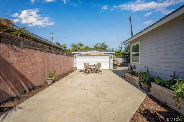 2731 N Rutgers Ave, Long Beach, CA 90815 - view of patio with an outbuilding, a garage, fence, and outdoor dining area