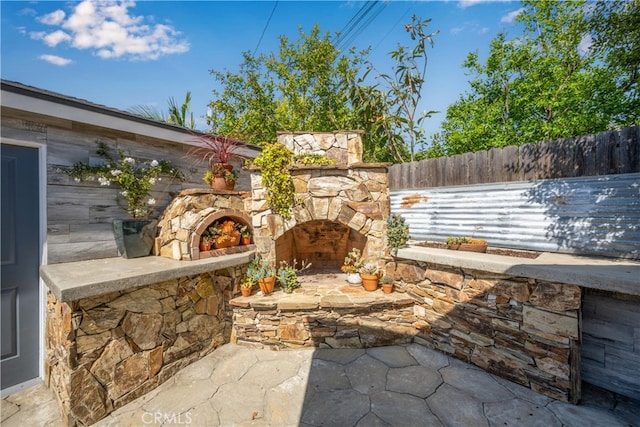2731 N Rutgers Ave, Long Beach, CA 90815 - view of patio featuring an outdoor stone fireplace and a fenced backyard