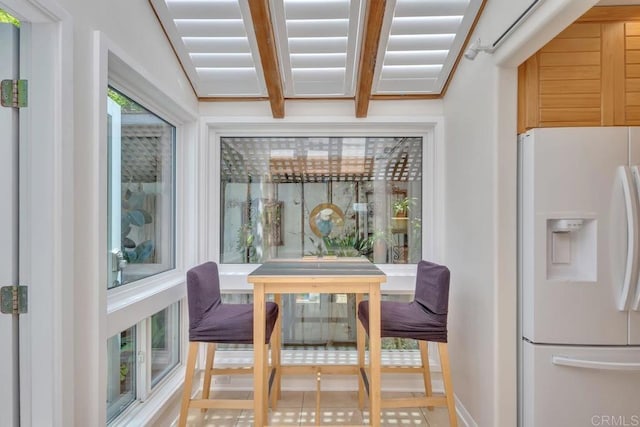 dining room featuring baseboards and beam ceiling