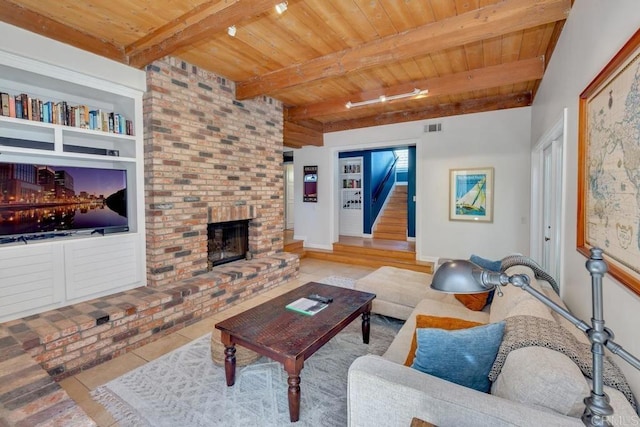 living area with tile patterned floors, wood ceiling, beam ceiling, a fireplace, and stairs