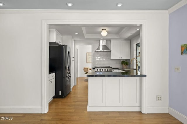 2426 Warbler Ave, Ventura, CA 93003 - kitchen with freestanding refrigerator, wall chimney range hood, dark countertops, a sink, and white cabinetry