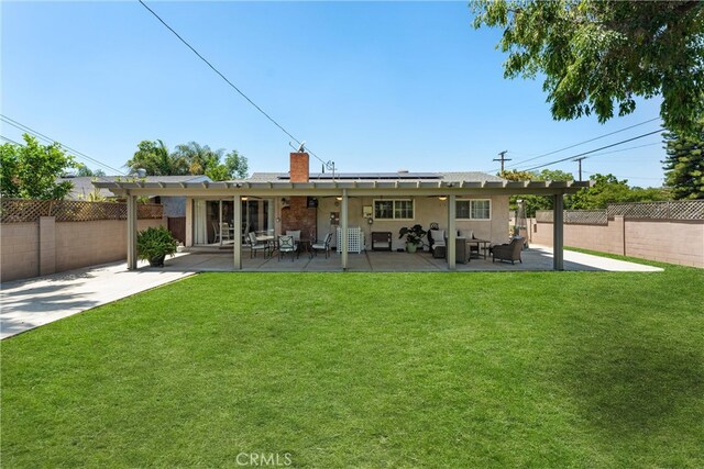180 N De Lay Ave, Covina, CA 91723 - back of property featuring solar panels, a fenced backyard, a chimney, and a patio area