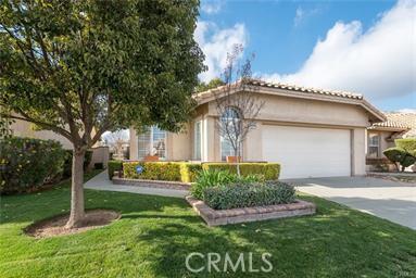 1331 Pauma Valley Rd, Banning, CA 92220 - view of front facade featuring an attached garage, concrete driveway, stucco siding, and a front lawn