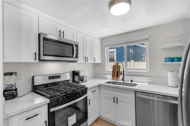 1075 Molino Ave Unit D, Long Beach, CA 90804 - kitchen with appliances with stainless steel finishes, a sink, white cabinets, light stone counters, and open shelves
