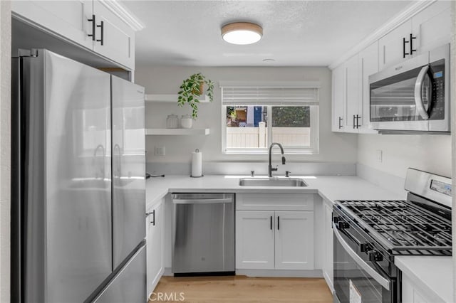 1075 Molino Ave Unit D, Long Beach, CA 90804 - kitchen featuring appliances with stainless steel finishes, a sink, white cabinetry, light countertops, and a textured ceiling