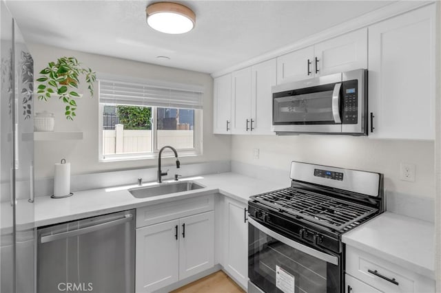1075 Molino Ave Unit D, Long Beach, CA 90804 - kitchen with appliances with stainless steel finishes, a sink, white cabinetry, and light countertops