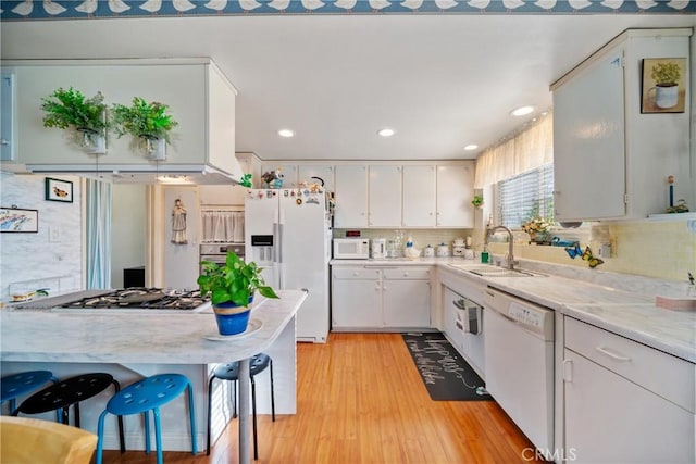 2204 Ruiz Pl, Hacienda Heights, CA 91745 - kitchen with a sink, white appliances, light countertops, tasteful backsplash, and light wood-style floors