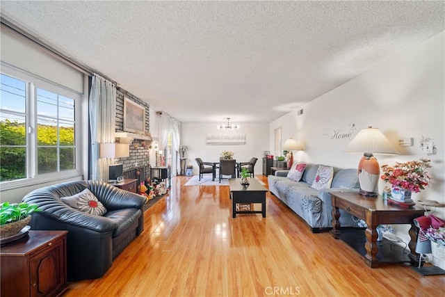 2204 Ruiz Pl, Hacienda Heights, CA 91745 - living room featuring a textured ceiling, light wood-style floors, plenty of natural light, a chandelier, and a brick fireplace