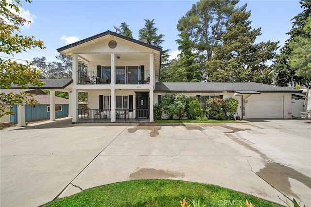 2137 N Murray St, Banning, CA 92220 - neoclassical home featuring a balcony, stucco siding, driveway, and a garage