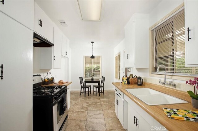 10345 Sherman Grove Ave, Sunland, CA 91040 - kitchen featuring stainless steel gas range oven, under cabinet range hood, a sink, white cabinets, and light countertops