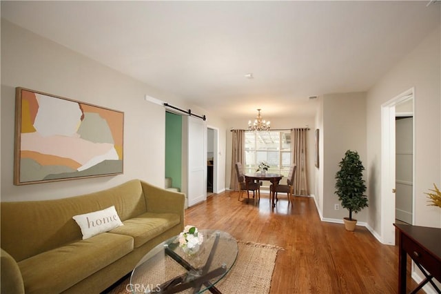 10345 Sherman Grove Ave, Sunland, CA 91040 - living room featuring a barn door, a chandelier, light wood finished floors, and baseboards