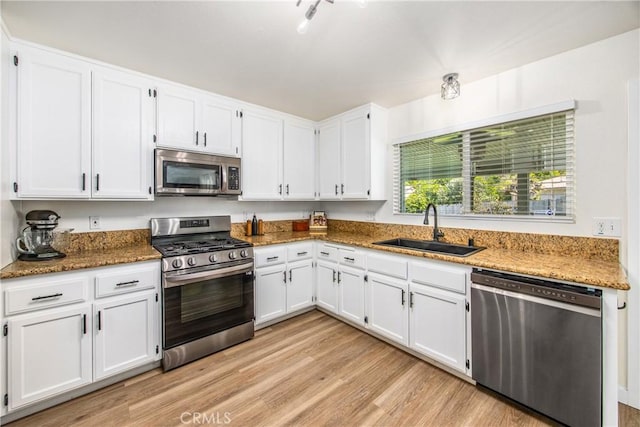 1388 E 39th St, San Bernardino, CA 92404 - kitchen featuring stainless steel appliances, a sink, white cabinets, stone counters, and light wood-style flooring