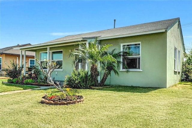 view of front of home featuring a front yard and stucco siding