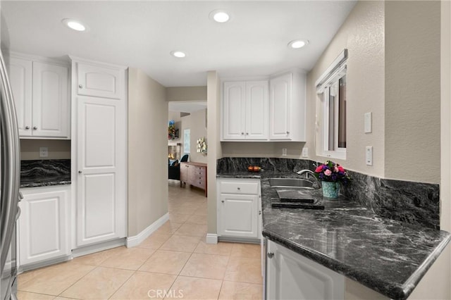 27345 Via Capri, San Juan Capistrano, CA 92675 - kitchen featuring a sink, white cabinets, light tile patterned floors, dark stone countertops, and freestanding refrigerator