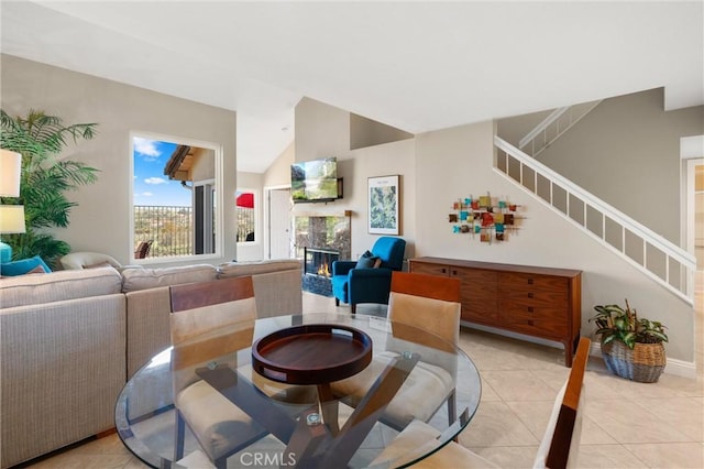 27345 Via Capri, San Juan Capistrano, CA 92675 - dining room with light tile patterned floors, a fireplace, stairway, lofted ceiling, and baseboards