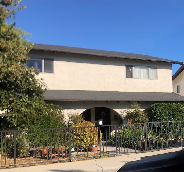 view of front of house featuring stucco siding and fence