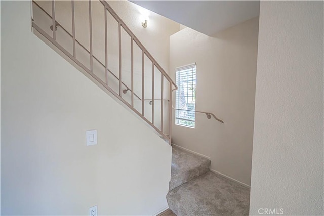 stairway featuring carpet flooring and baseboards