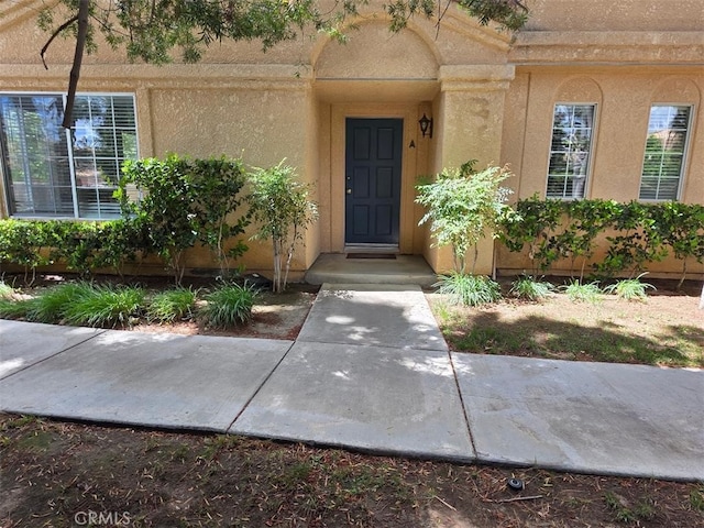 view of exterior entry with stucco siding